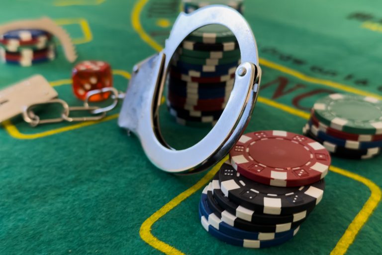 Cards cubes and chips Handcuffs close-up. Royal flush poker. Prohibited gambling concept, internet casino underground